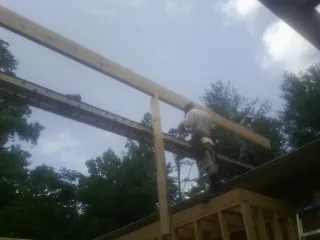 Carpenter setting a ridge beam over a new addition frame — Ice Dam Removal by Roofing Brothers in Huntley