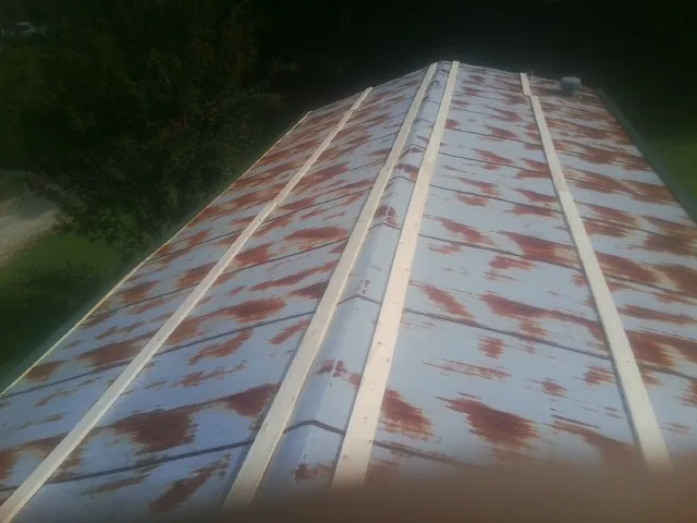 Rusted metal roof panels with new wood purlins before replacement — Storm Damage Roof Repair in Huntley by Roofing Brothers